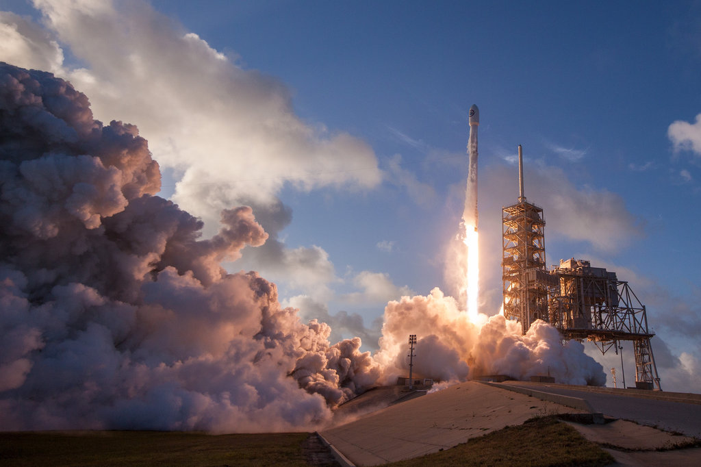 Spacecraft taking off in a blaze of smoke and fire.