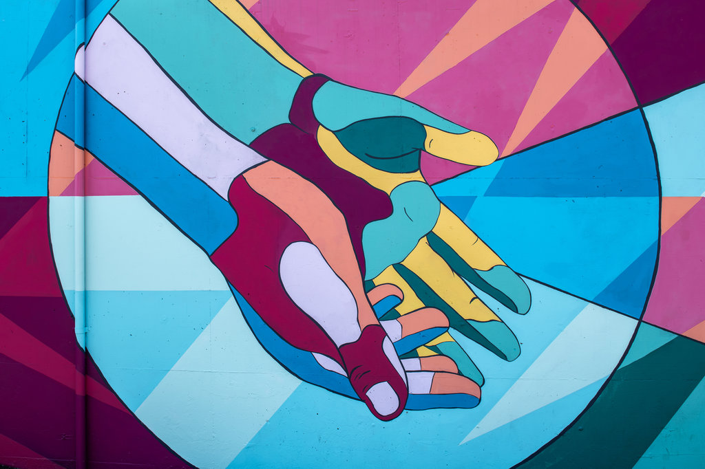 A painting depicting a pair of colorful hands.