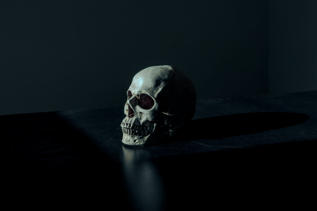 A human skull figurine on a black surface.