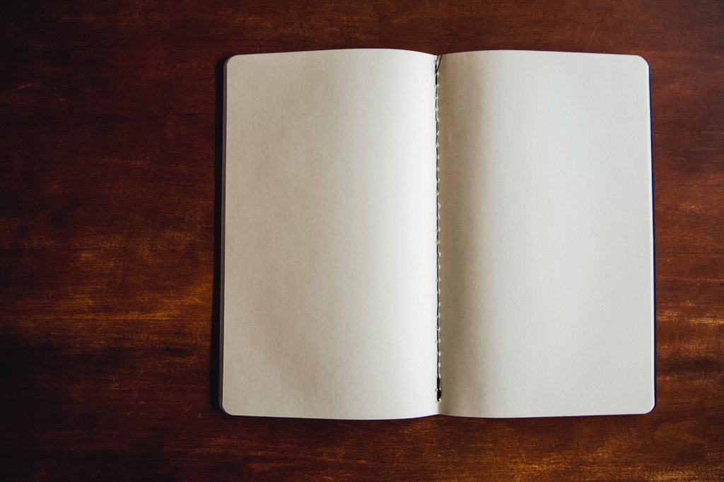 An open blank notebook on a desk.